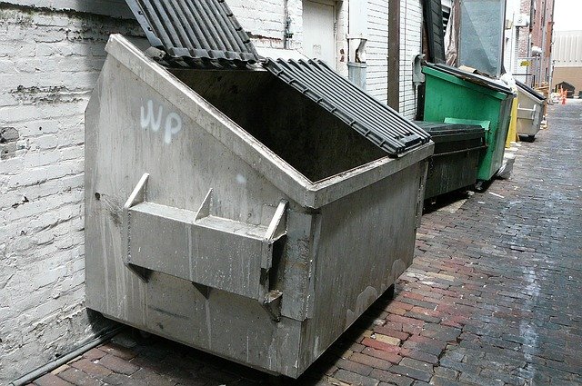 Several dumpsters for rent in an alley